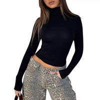 Fashion-forward ensemble featuring a black turtleneck fitted top paired with leopard print jeans | Bold personality and contemporary edge in statement street style