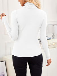 Back view of VRCÔMFY satin white turtleneck top with sculpted silhouette, styled with noir black trousers and oat beige bag with gilded hardware | Architectural minimalism and metropolitan elegance in a curated lifestyle composition