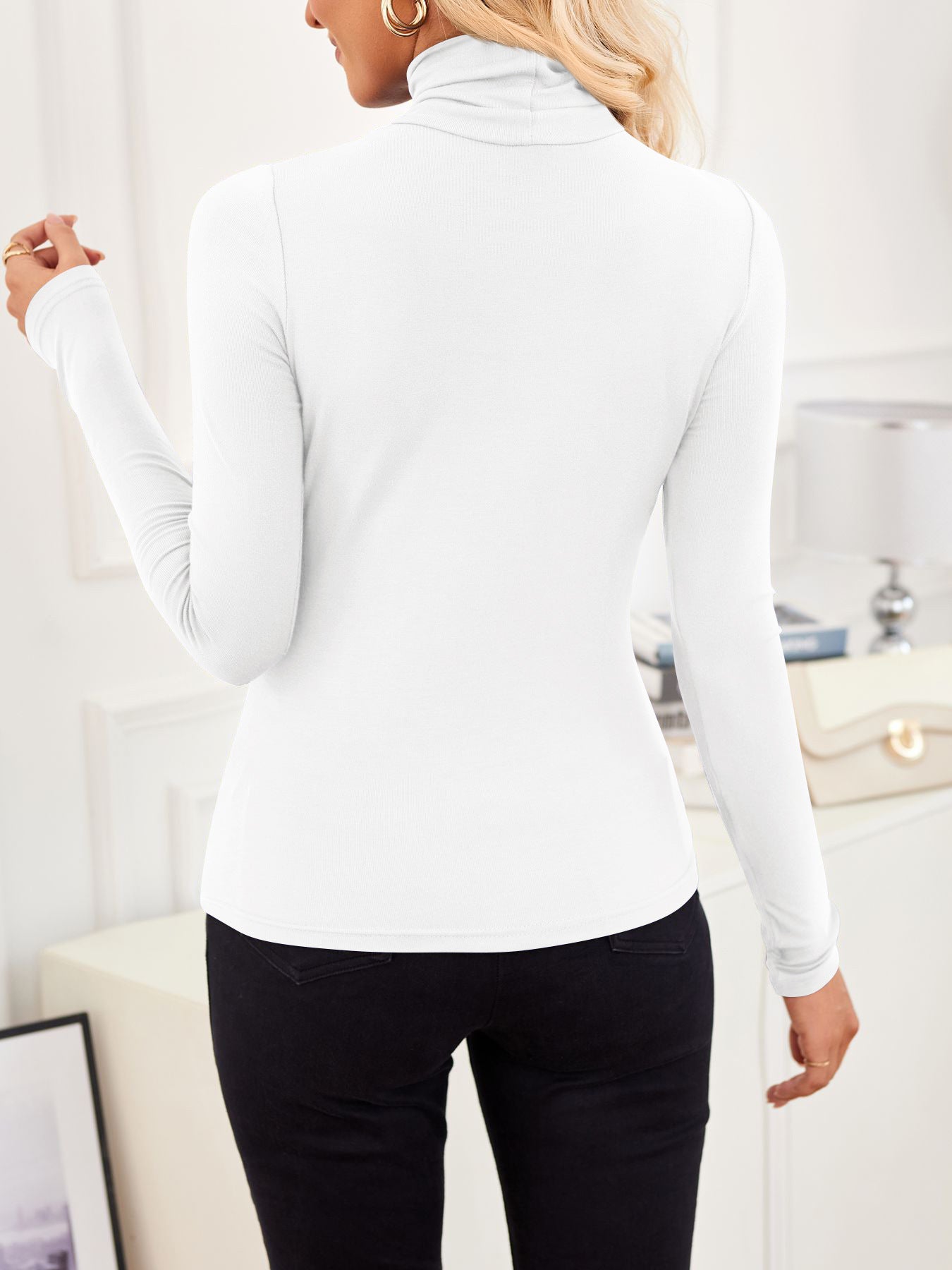 Back view of VRCÔMFY satin white turtleneck top with sculpted silhouette, styled with noir black trousers and oat beige bag with gilded hardware | Architectural minimalism and metropolitan elegance in a curated lifestyle composition