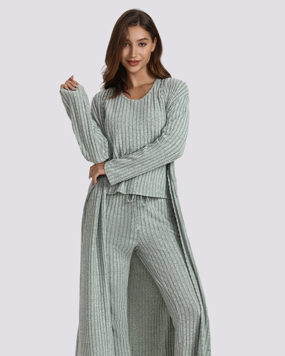Woman wearing a green ribbed lounge set on a gray background