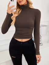 VRCÔMFY amber brown turtleneck cropped top with contour-defining fit, styled with artfully distressed black jeans | Urban minimalist edge and effortless sophistication for fashion-forward street style