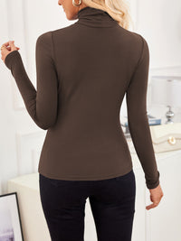 Back view of VRCÔMFY mocha brown turtleneck top with sculpted silhouette, styled with tailored black trousers and sand beige bag featuring gilded lock-clasp | Architectural minimalism and refined urban elegance in a curated lifestyle setting