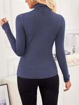 Back view of VRCÔMFY deep cobalt blue turtleneck top with architectural lines, paired with precision-tailored black trousers | Streamlined elegance and metropolitan sophistication in minimalist urban style