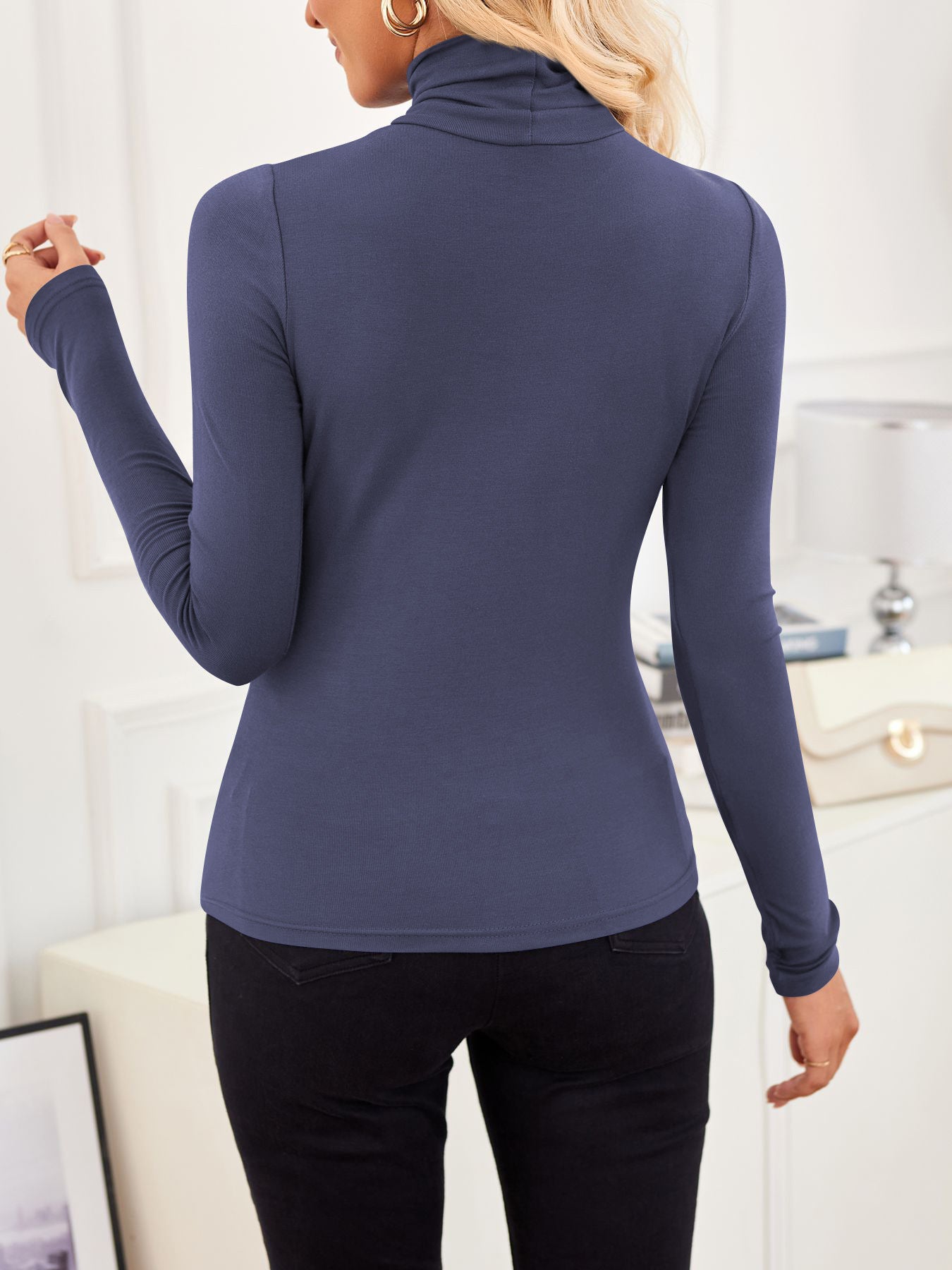 Back view of VRCÔMFY deep cobalt blue turtleneck top with architectural lines, paired with precision-tailored black trousers | Streamlined elegance and metropolitan sophistication in minimalist urban style
