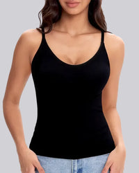 A woman wearing a black spaghetti-strap tank top paired with light blue jeans, shown from the neck down against a solid gray background.