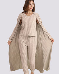 Woman wearing a beige ribbed outfit with a matching long cardigan on a gray background