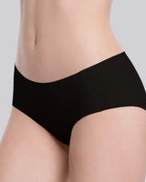 Close-up of a model wearing black high-waisted briefs against a light gray studio background.