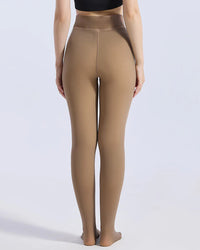 A model shown from the back wearing high-waisted, seamless tights in a warm taupe-brown shade, paired with a black crop top against a light gray studio background.