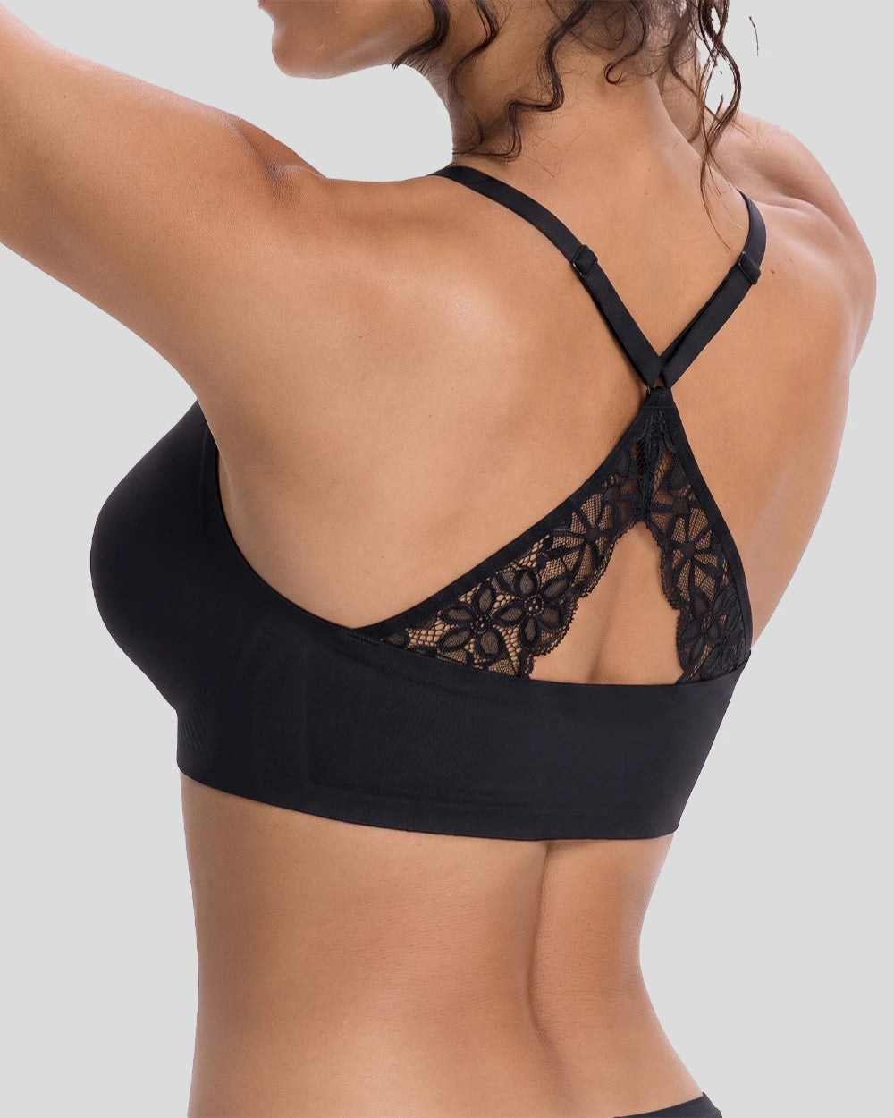 Rear view of a woman wearing a black wireless bra with delicate lace back panel and crossover straps, showcasing a comfortable seamless fit and elegant back design.