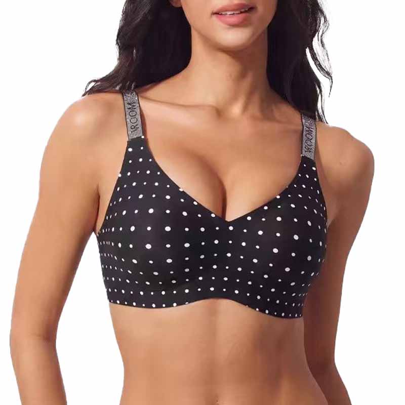 A woman wearing a black bra with white polka dots and gray adjustable straps printed with the brand name 'MOON'.