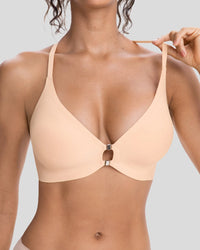 Close-up of a woman wearing a peach beige wireless bra with a center cutout detail and thin adjustable shoulder straps, featuring a smooth seamless design for comfortable everyday wear.