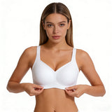 Woman wearing a white bra on a plain background