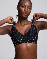 VRCOMFY Black polka dot bra with white polka dots worn by a person on a white background
