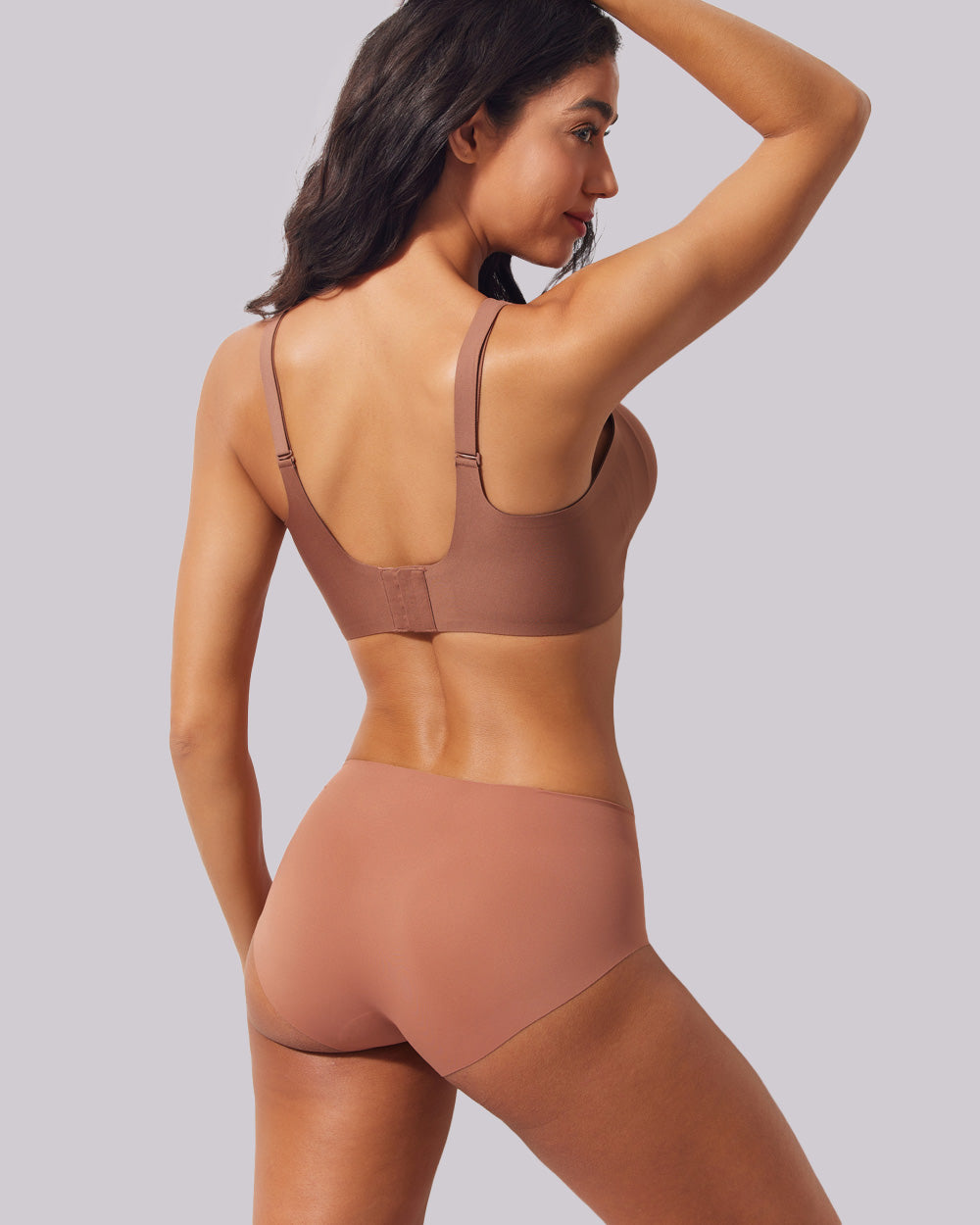 A woman shown from the back wearing a matching two-piece lingerie set in a muted dusty rose-brown color, featuring a bralette and high-waisted briefs, against a solid light gray background.