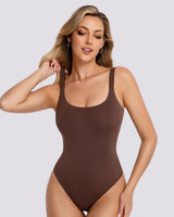 A woman modeling a brown scoop-neck bodysuit against a solid light gray background.