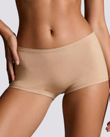 Close-up of a model wearing high-waisted, seamless shapewear briefs in a light beige shade against a neutral gray background.