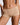 Close-up of a model wearing high-waisted, seamless shapewear briefs in a light beige shade against a neutral gray background.