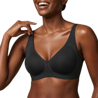 Woman wearing a black bra against a white background