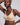 A model wearing a beige wireless bralette with a small teardrop cutout at the center, photographed against a solid light gray background.