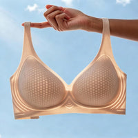 Lightweight beige breathable bra with perforated cups, held up against a clear blue sky to highlight comfort and airflow.