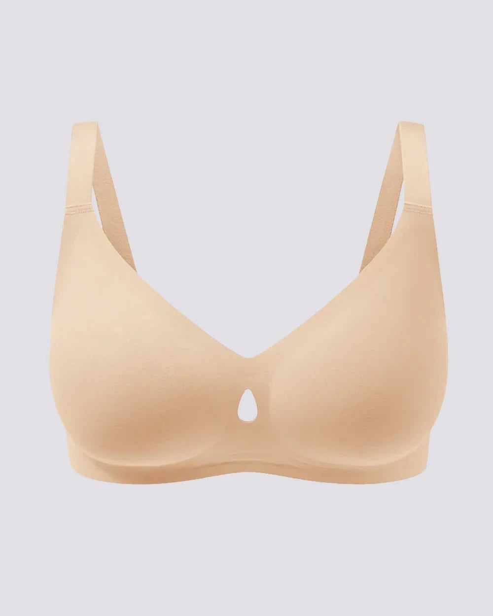 A light beige wireless bra with a small teardrop-shaped cutout at the center of the bust, displayed against a solid light gray background.