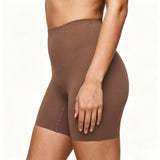 Brown shapewear shorts worn by a person on a white background