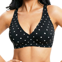 Black polka dot bra with white polka dots worn by a person on a white background