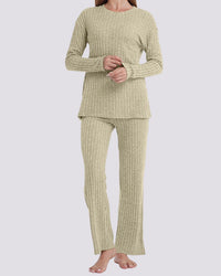A woman modeling a two-piece ribbed knit pajama set in a light sage green color, consisting of a long-sleeve top and matching pants, against a solid light gray background.