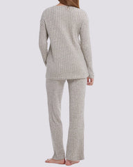 A woman shown from the back wearing a ribbed knit two-piece pajama set in a light oatmeal beige color, consisting of a long-sleeve top and matching pants, against a solid light gray background.