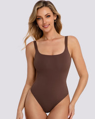 A woman modeling a solid brown one-piece bodysuit or shapewear top against a light gray studio background.