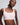 VRCÔMFY light pink seamless bralette with soft stretch fabric and wireless support, close-up front view of a model against a light gray studio background.