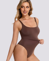 A woman modeling a solid brown one-piece bodysuit or shapewear garment against a light gray studio background.