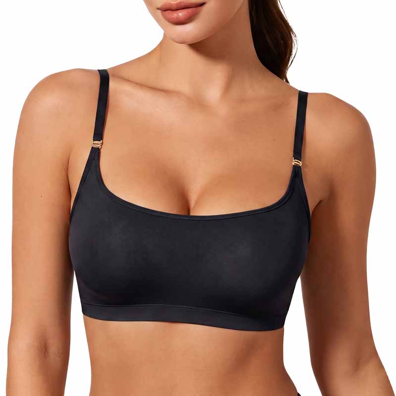 A woman wearing a black bralette with thin adjustable straps and small gold-tone metal accents at the strap joints, shown against a plain white background.