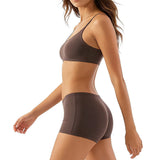 Woman wearing a brown sports bra and shorts set on a white background