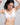 A woman wearing a vrcomfy white seamless underwire bra, shown from the chest up against a light gray studio background.