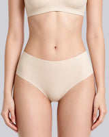 A model wearing high-waisted, seamless underwear in a light beige shade, paired with a matching bra top, shown against a solid light gray background.