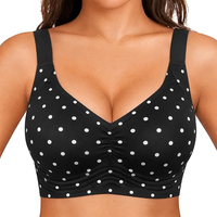 Black sports bra with white polka dots worn by a model on a white background