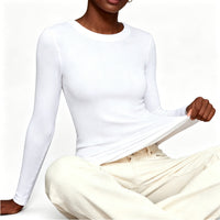 Person wearing a white long-sleeve top and beige pants on a white background