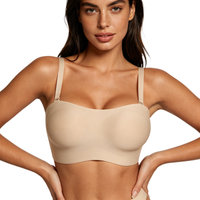 Woman wearing a beige bralette against a plain background